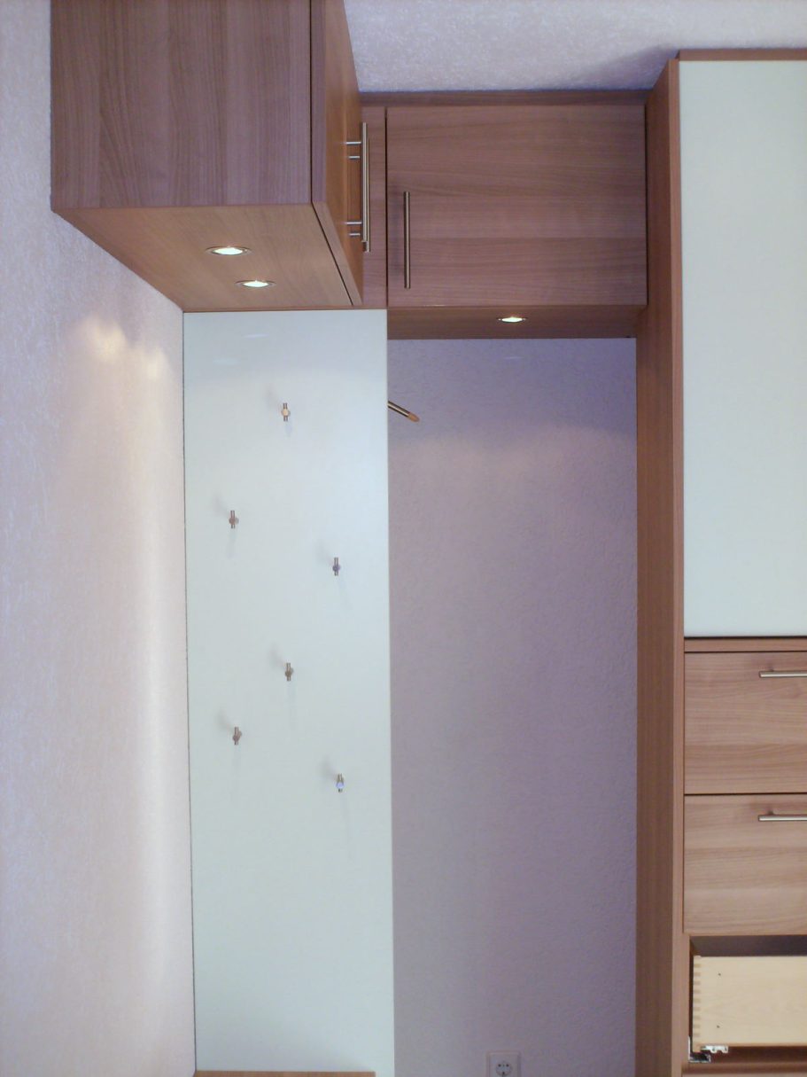 Garderobe Minimalistische Inneneinrichtung mit Holzschränken und hellem Hintergrund.