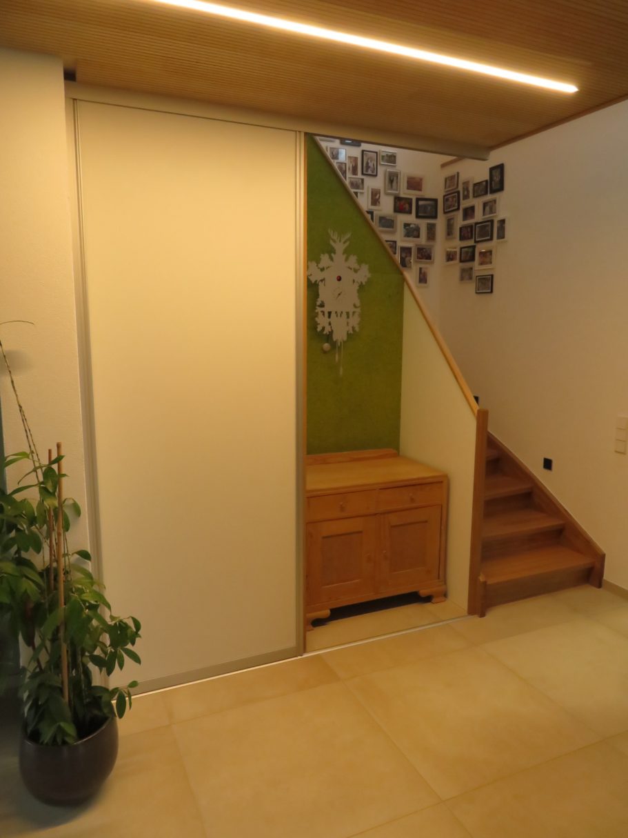 Nischenschrank Ein heller Eingangsbereich mit einer Holztreppe und einem grünen Akzent.