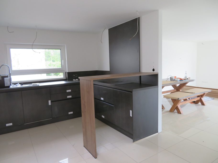 Küche Moderne Küche mit Holz- und dunklen Möbeln, offener Wohnbereich im Hintergrund.